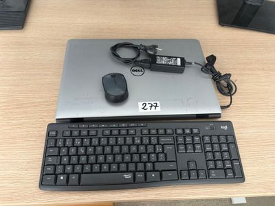 un ordinateur portable et un clavier posés sur un bureau, avec une souris à côté