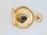 a close up of a pocket watch on a white surface