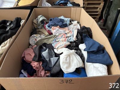 a cardboard box full of clothes sitting on top of a table