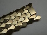 un gros plan sur un bracelet composé de pièces d'or