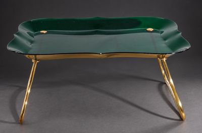 une photo représentant un plateau vert aux pieds dorés posé sur une table