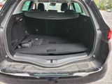 the back of a car with its trunk open and luggage in the trunk