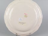 underside view of a white plate on a stand on a gray surface