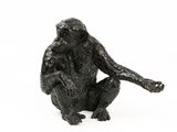 statue of a monkey sitting on a white surface