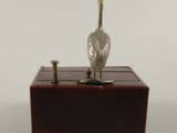 a silver bird sitting on top of a wooden box