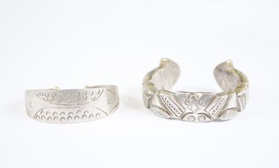 une paire de bracelets manchette en argent sur fond blanc
