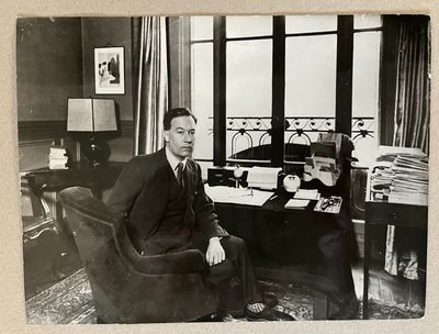 photographie en noir et blanc d'un homme assis à un bureau dans un bureau