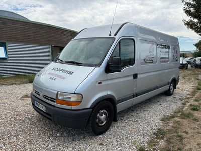 a silver van that is parked in a gravel lot