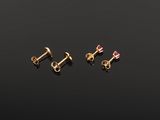 a set of three gold screws with pink sapphire stones