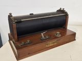 une petite boîte en bois sur laquelle se trouve un objet en métal