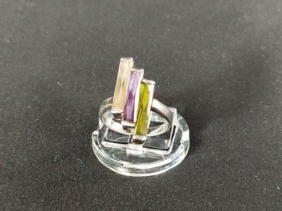 une bague sertie de trois pierres de couleurs différentes