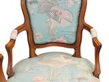 a blue chair with a floral upholstered back and arms
