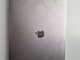 an apple laptop sitting on a wall next to a wall mounted air conditioner