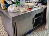 a kitchen with a lot of clutter on the counter