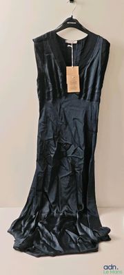 the black dress is hanging on a hanger on the wall