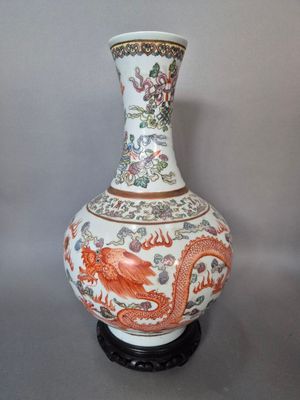 un vase orné d'un dragon, posé sur un socle