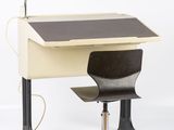 a desk with a chair and a lamp on top of it