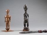 two wooden figurines and a knife on a table