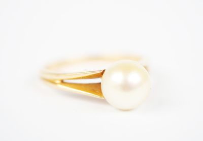 a close up of a pearl ring on a white surface