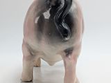 a small figurine of a sheep on a white surface