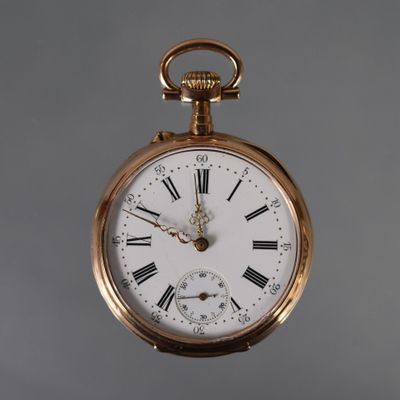 a gold pocket watch with roman numerals on the face