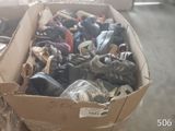 plusieurs paires de chaussures dans une boîte en carton posée sur le sol