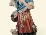 une figurine représentant une femme tenant un oiseau et un chien