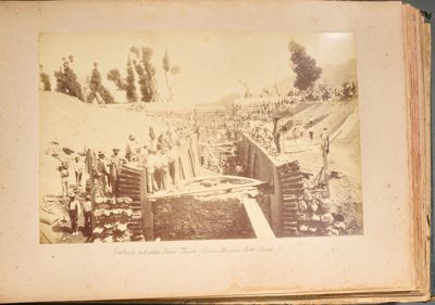 une vieille photo montrant un groupe d'hommes debout devant un mur