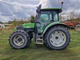 un tracteur vert garé dans l'herbe