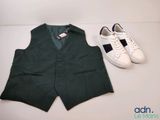 un gilet vert et une paire de baskets blanches posés sur une table