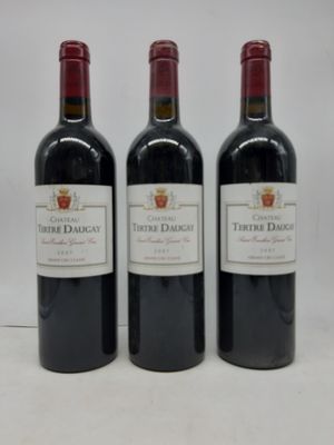 trois bouteilles de vin rouge posées côte à côte sur une table