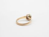 a close up of a gold ring with a green stone