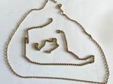 a gold chain with a heart on it on a white surface