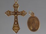 two gold crosses and a medal are shown against a gray background