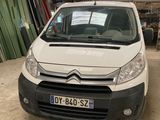 La camionnette blanche est garée dans le garage de l'immeuble.