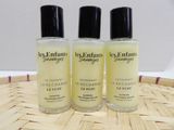 three bottles of perfume sitting on top of a bamboo mat