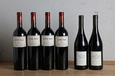six bottles of red wine are lined up on a wooden table
