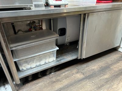 une cuisine avec un plan de travail en acier inoxydable et un réfrigérateur