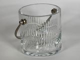 a glass ice bucket with a handle on a table