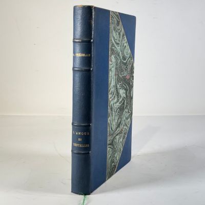 un vieux livre à la couverture bleue posé sur une table blanche