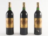 three bottles of wine sitting next to each other on a white surface
