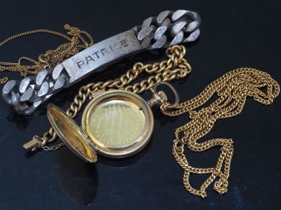 a gold pocket watch with a chain around it on a black surface