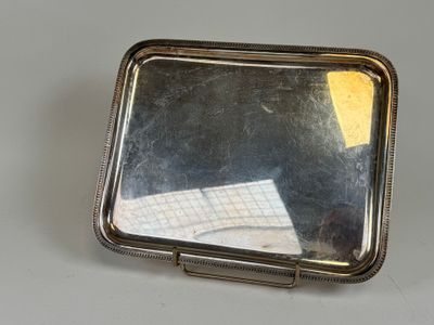 un petit miroir posé sur une table, à côté d'une feuille de papier