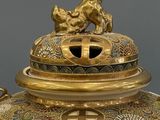 a large vase that has a gold decoration on it