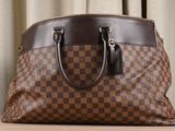 a brown and black handbag sitting on a table