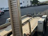 a trailer with a ladder attached to it in a parking lot