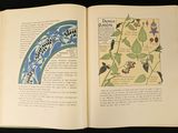 an open book with a picture of a bird and flowers on it