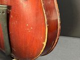 an old violin sitting on top of a table next to a wall