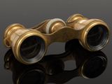 an old pair of binoculars sitting on top of a black surface