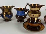 cinq vases de couleurs différentes posés sur une surface blanche